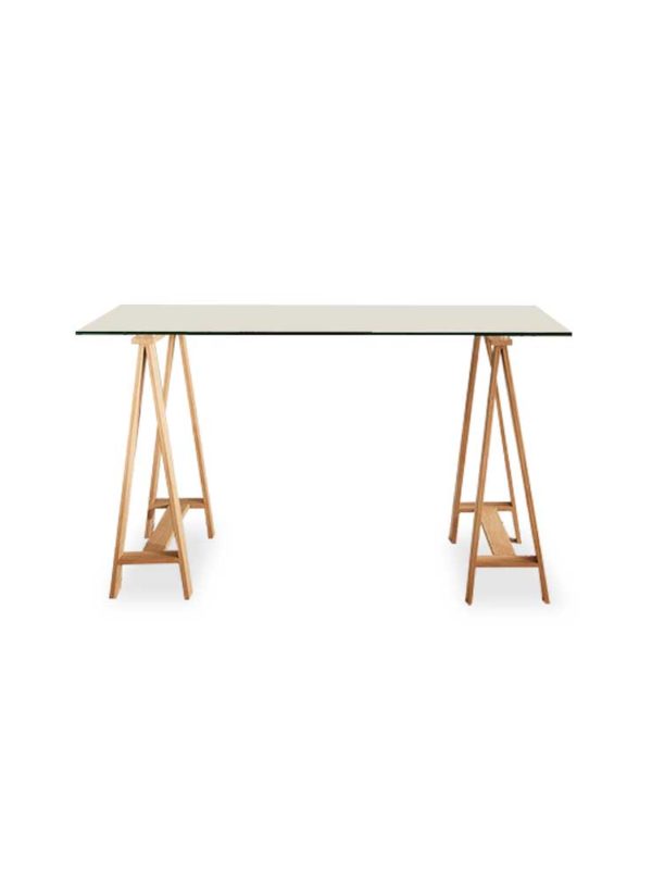 Waverley Trestle Desk, is a boss glass tabletop and metal legs finished in an oak-coloured foil.